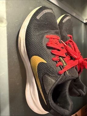 Nike Women’s Revolution black Sneakers with Gold Swoosh and Red Laces- Size 8